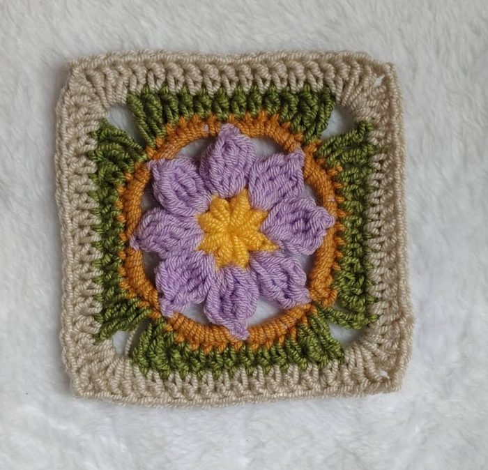Granny con flor lila, centro mostaza y borde verde tejido por una alumna