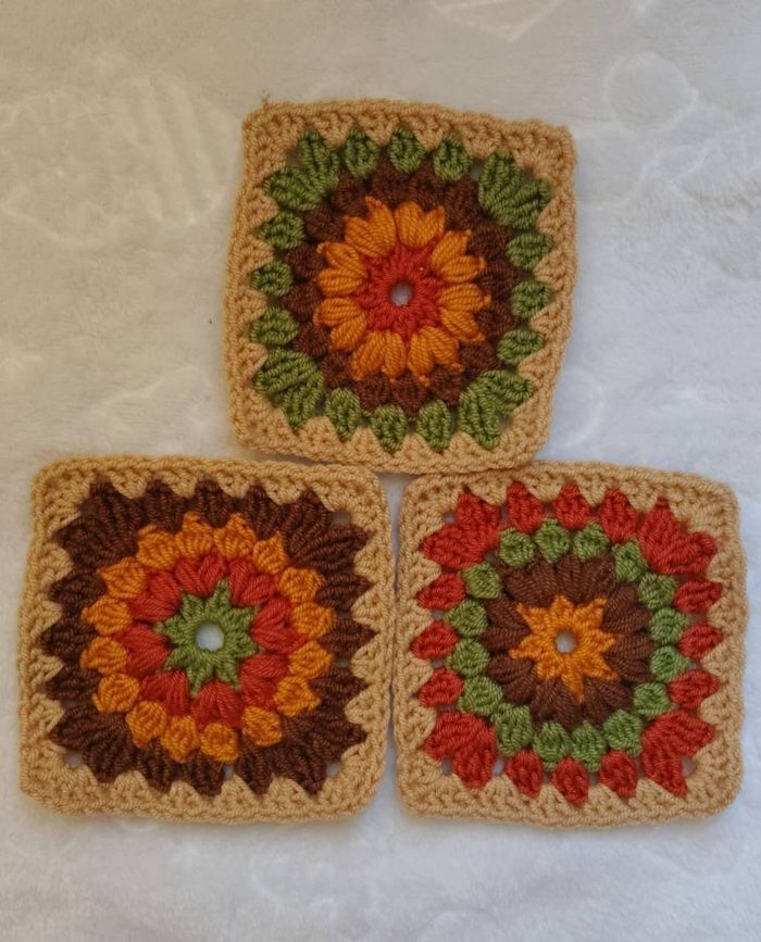 Tres grannys de flor en tonos otoñales tejidos por una alumna