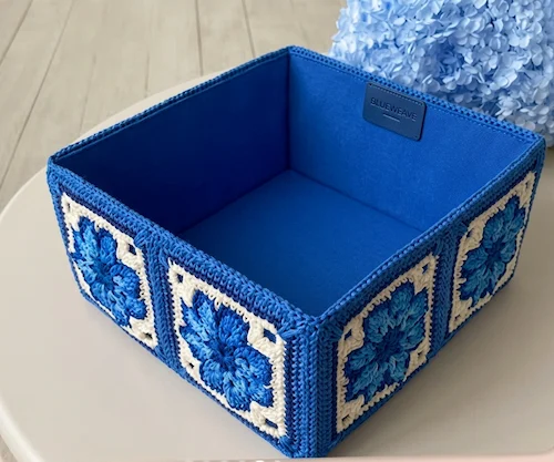 Caja organizadora azul con grannys de flor en sus lados
